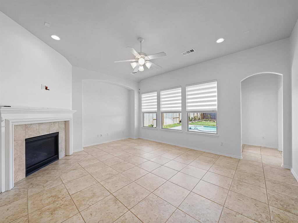 The spacious family room is the perfect gathering place for loved ones, anchored by a striking fireplace that serves as a focal point. Large windows flood the room with natural light and offer breathtaking views of your backyard oasis.