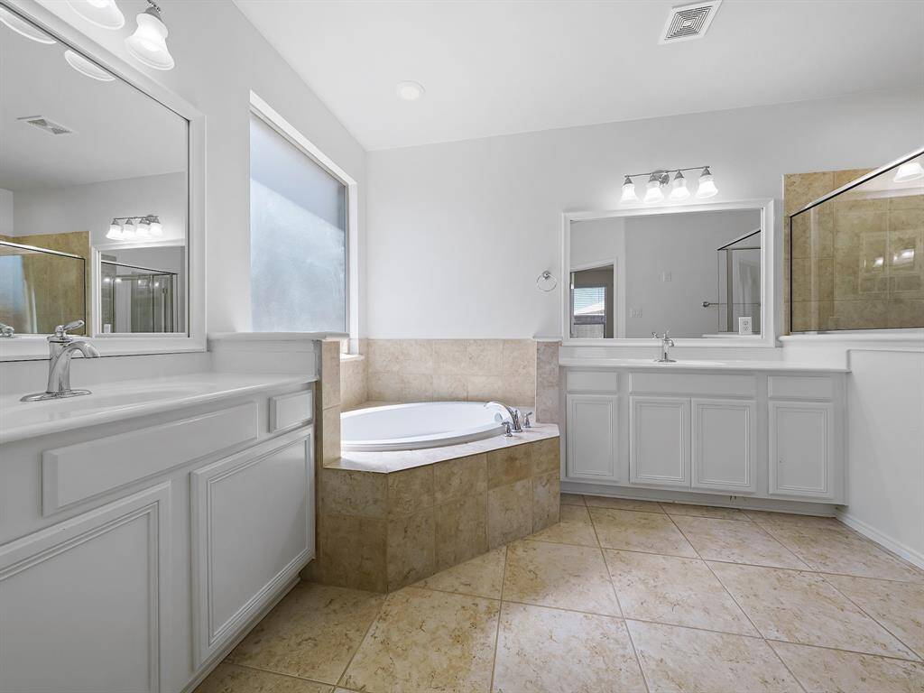 Escape to your luxurious ensuite bathroom. Enjoy a relaxing soak in the corner tub, the convenience of dual vanities and sinks, and a refreshing experience in the large separate shower."