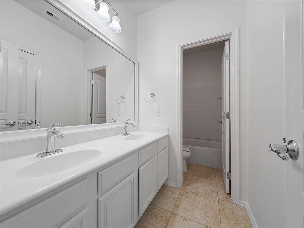 Enjoy the functionality and space of the secondary bathroom. A separate vanity area with dual sinks offers enhanced convenience and eliminates morning congestion. Perfect for sharing!