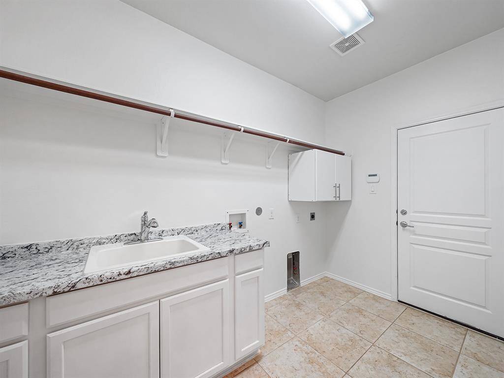 Enjoy the convenience of a huge utility room, thoughtfully equipped with a sink and cabinetry. Perfect for laundry, cleaning supplies, and keeping your home organized.