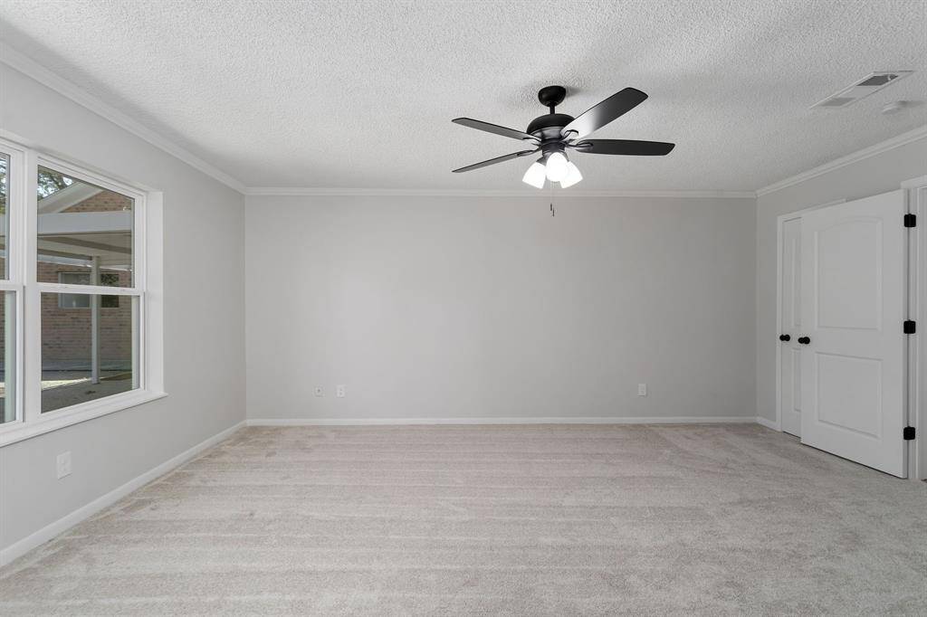 The room is elegantly framed with detailed crown molding and equipped with a ceiling fan to enhance airflow and maintain a pleasant atmosphere.