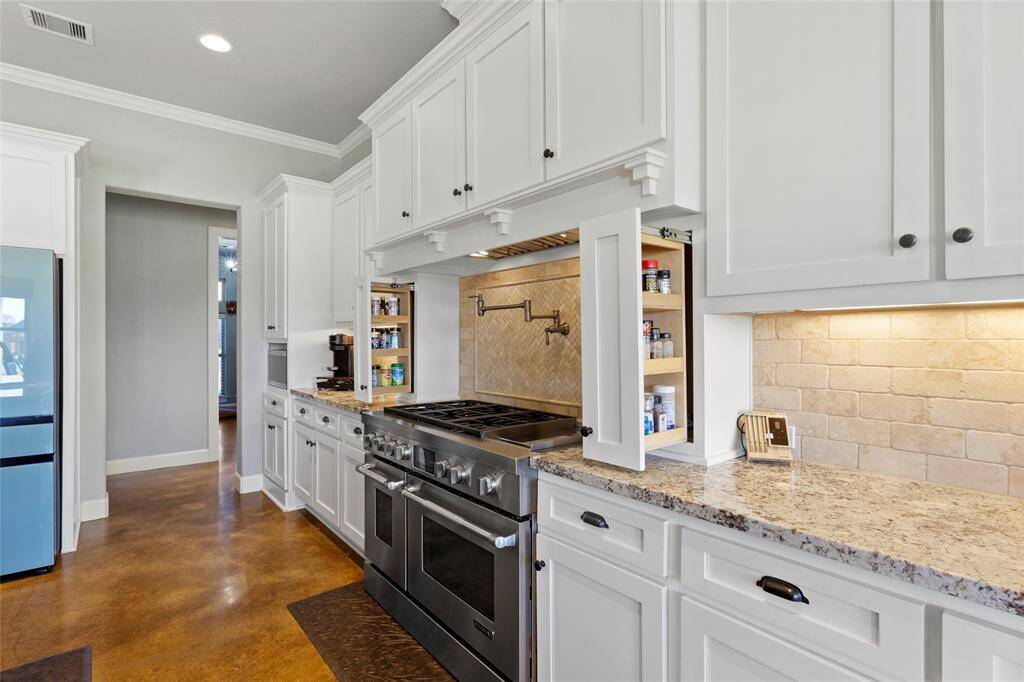 There are surprises everywhere you turn!  Check out these slide-out spice racks on either side of the range cooktop. The space is bright and modern, ideal for cooking and entertaining.