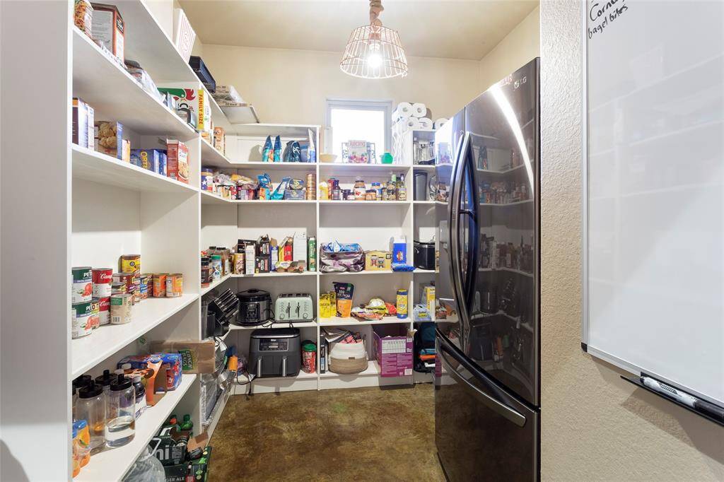 Butler's pantry with custom lighting, electrical, space for a refrigerator, and built-in storage for organization.