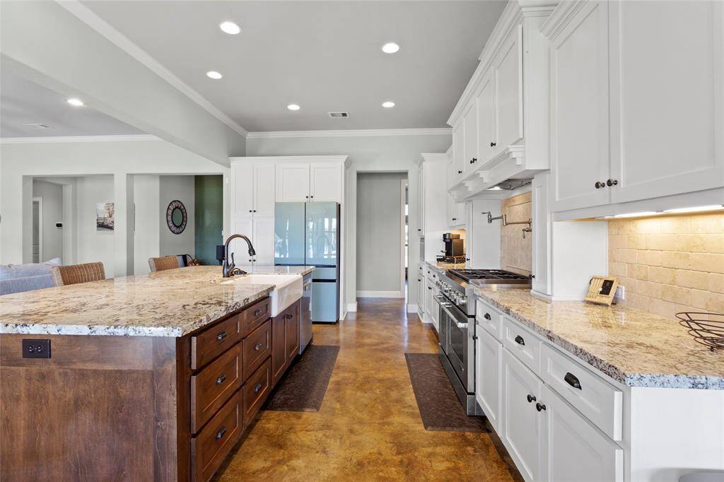 This modern kitchen is a chef's dream including Solid Wood Cabinetry with Soft Close Drawers and Cabinets, Slide Out Shelves and Organizers, JennAir 6 Burner Stainless Gas Range Cooktop w/ Griddle and Double Oven, New Vent Hood, Motor, LED Lighting & Roof Vent Upgrade (2024), New Bosch Dishwasher (2024), New Sink Disposal with Air Switch (2024), New Glass Rinser (next to sink 2024), New Sink Faucet (2024), and Cast Iron with Porcelain Overlay Farmhouse Sink.
