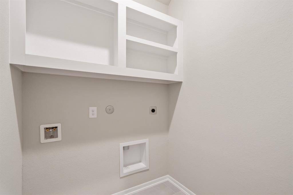 The laundry room layout is carefully planned for optimal workflow with designated areas for washing, drying, and storing.
