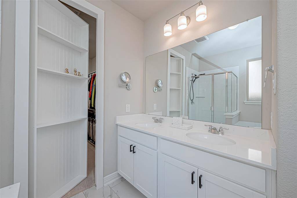 Dual Sinks and Custom Closet leading to walk in closet