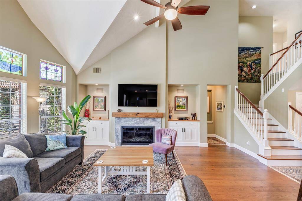 The large living room can accommodate large seating arrangements. To the right of this room is the primary bedroom and staircase to the second floor.