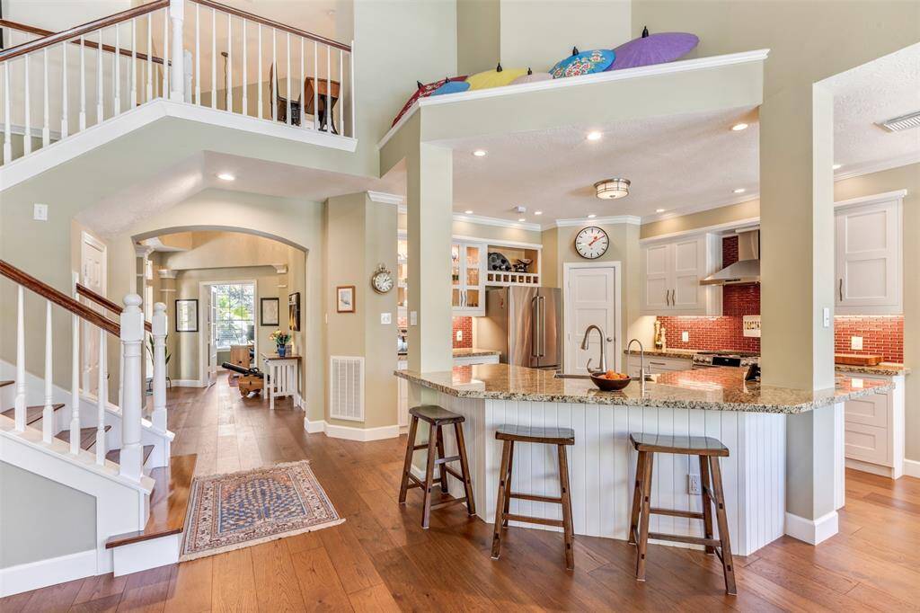 Here's a view of the renovated kitchen. A local Master Craftsman updated this home with recessed lighting, hardwood cabinets, soft closed drawers, stainless steel appliances, granite counters, hammered sink, and a one level island with seating.