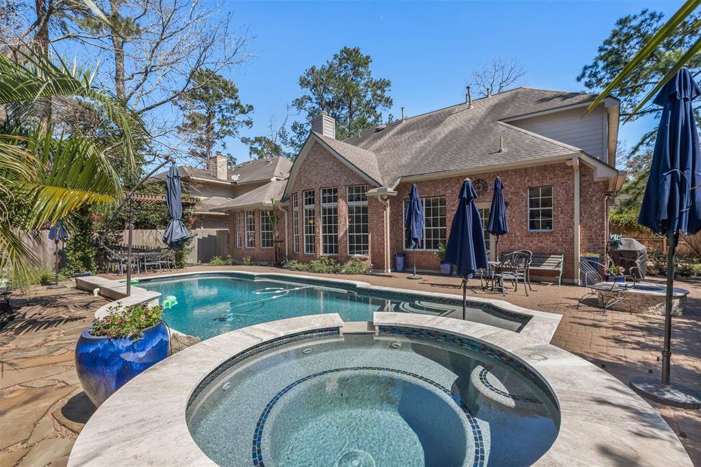 This spa-like backyard has a gorgeous saltwater pool with a sun deck entry and built in umbrella, ledges on both sides, and both pool and spa can be heated.  To the right of the pool is a grass area for kids or dogs.