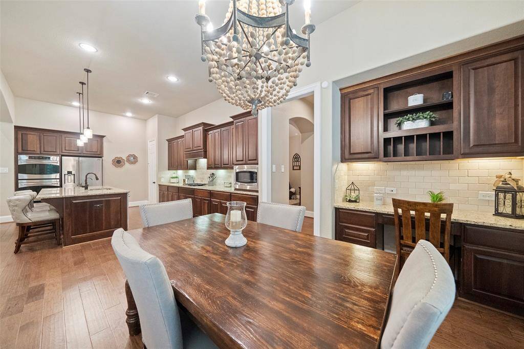 Casual dining features a fabulous designer chandelier & desk area with lots of cabinets for storage