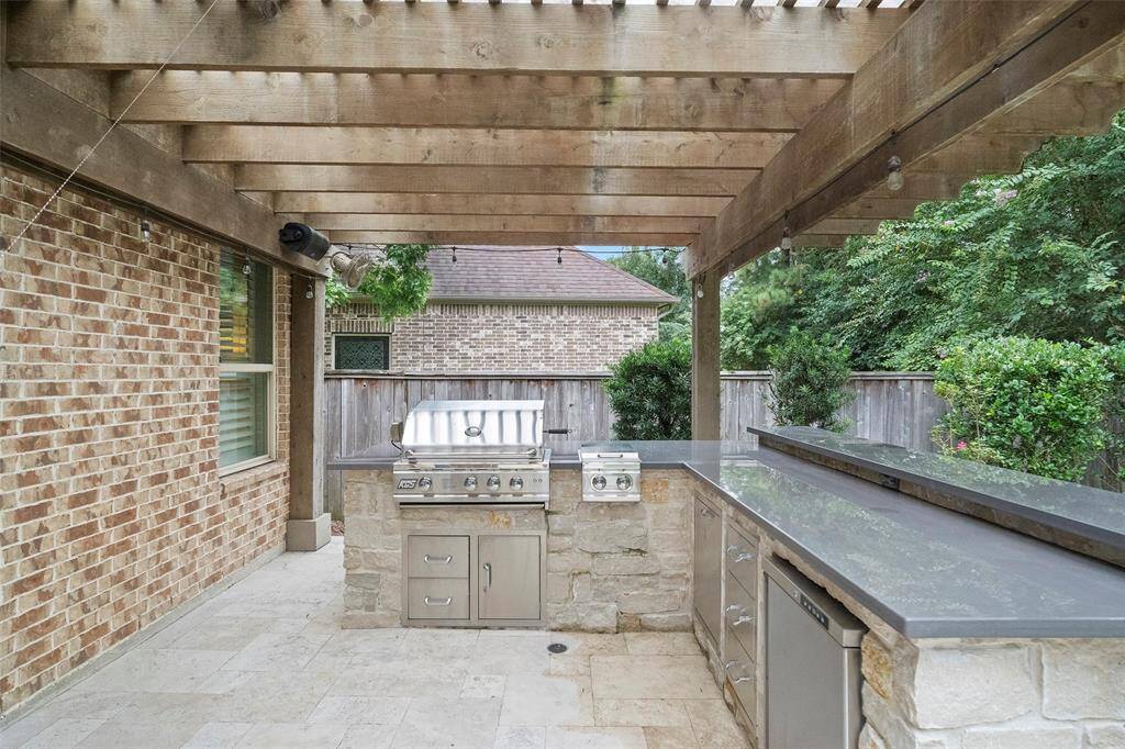 Full covered outdoor kitchen/ sit-up bar area with fridge.
