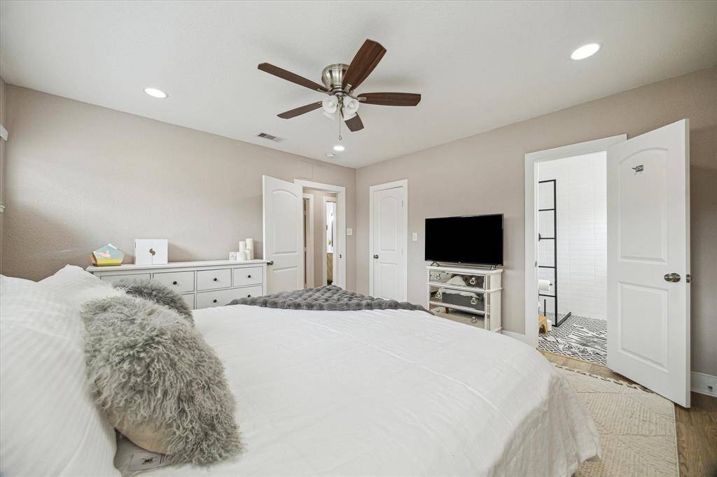 Another view of the primary, showing the bathroom and the closet doors.
