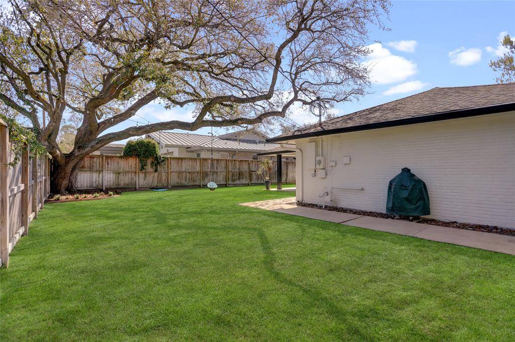 The yard continues around the garage, offering more yard space that is not visible from the house or patio.