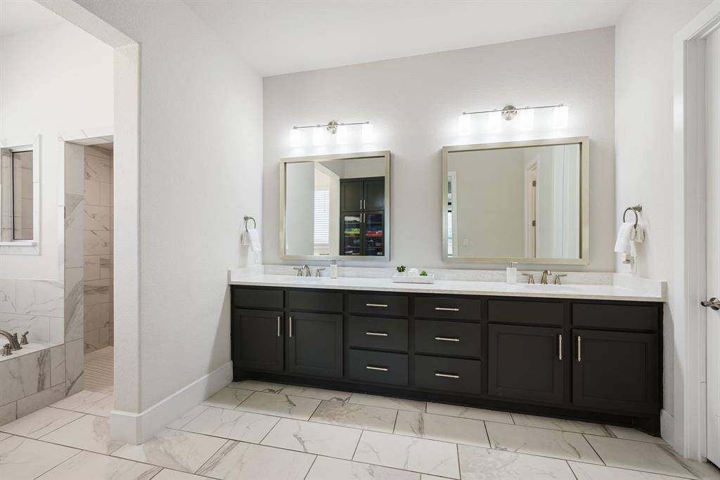 Updated quartz counters with double sinks. Stylish vanity, modern pulls and framed mirrors.