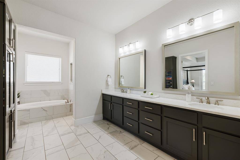 Matching linen closet leading to bathing area with separate tub and large walk in shower.