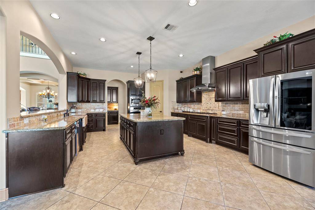 Your chef-inspired kitchen is ready to elevate your culinary experiences! This stunning space offers exquisite granite countertops complemented by a stylish stone backsplash, creating a harmonious blend of elegance and functionality. Equipped with top-of-the-line stainless steel appliances, it invites culinary creativity at every turn. The rich cabinets exude sophistication, while the under-cabinet and recessed lighting illuminate the area beautifully, enhancing both ambiance and practicality.