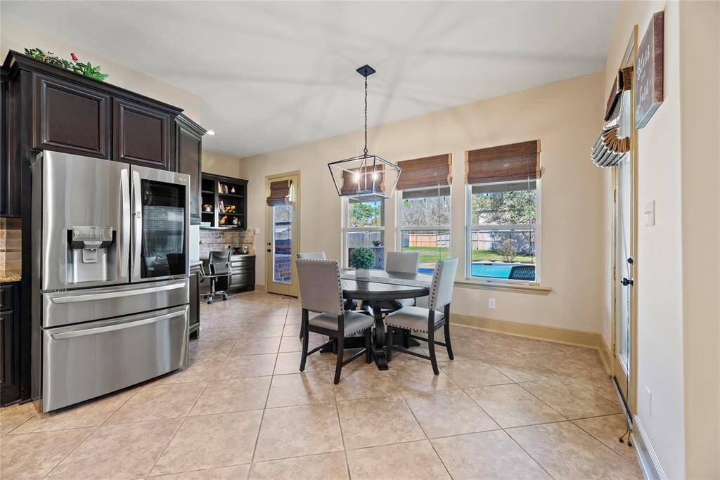 The breakfast room is ideal for a full-sized table and features easy care floors, overhead chandelier, and large bright windows giving picturesque views of the backyard.