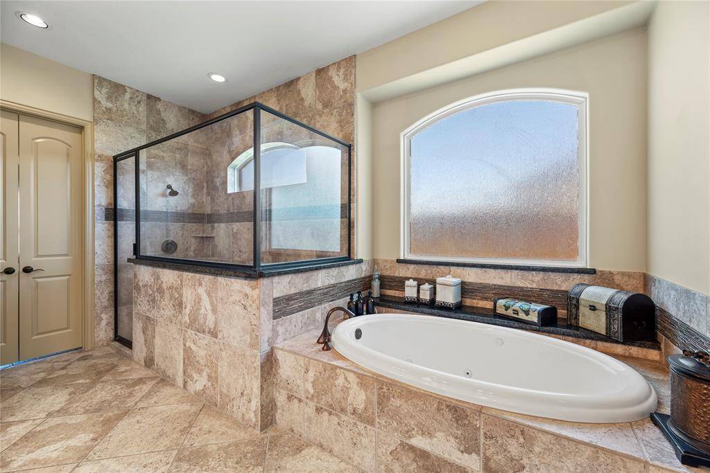 Expansive walk-in shower invites refreshment while the separate soaking tub promises relaxation for those quiet moments.