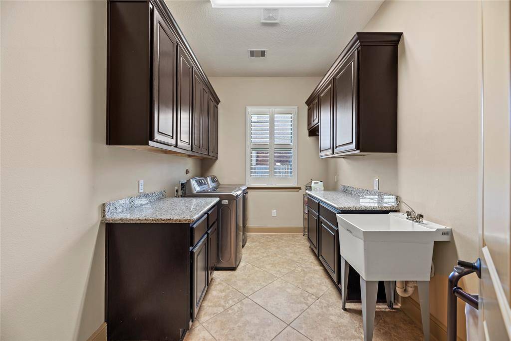 This well-appointed space includes ample storage and efficient organization, making laundry day a breeze while keeping your home tidy and functional. With extra sink and plenty of room for an additional refrigerator or freezer.