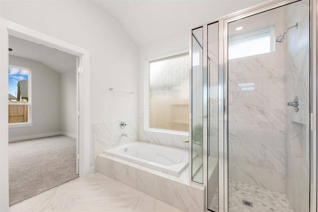 Featuring dual-sink vanity, luxurious bath, and tile flooring