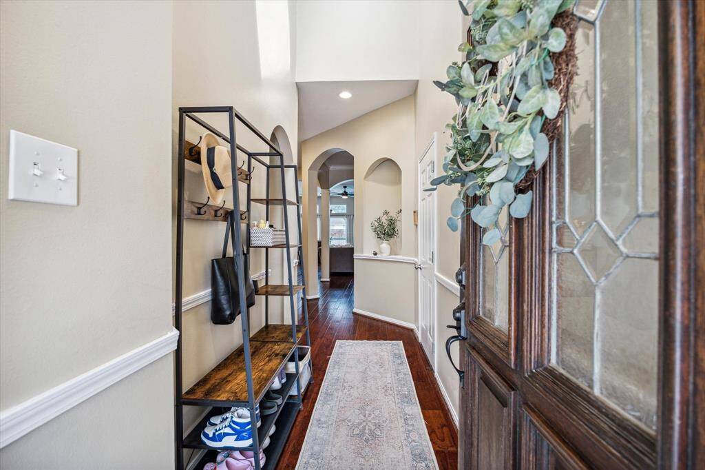 Attractive engineered wood floors and decorative enclave lead to an arched entry to this living space.  3 secondary bedrooms are located to the left of the entryway and the primary bedroom is located in the back of home, overlooking the pool area.  What a beautiful entryway!
