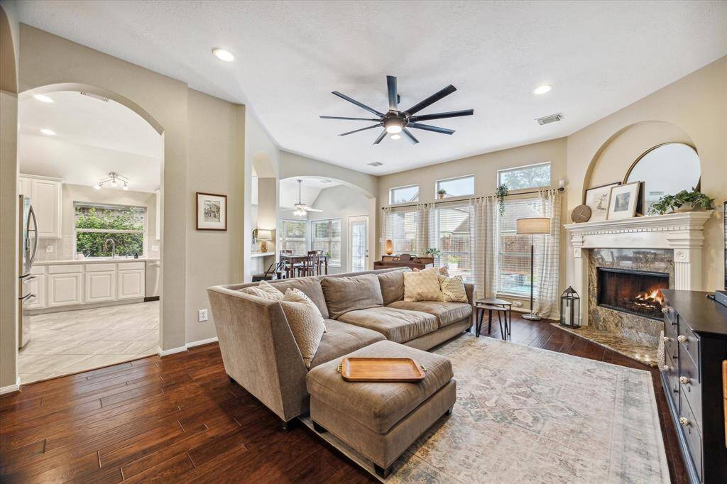 A cozy fireplace in this open living area and 3 large windows with transom windows above make this a beautiful living space. This room opens to the spacious kitchen and can be seen from the dedicated dining area. You can see the backyard oasis with a pool and hot tub from this room.