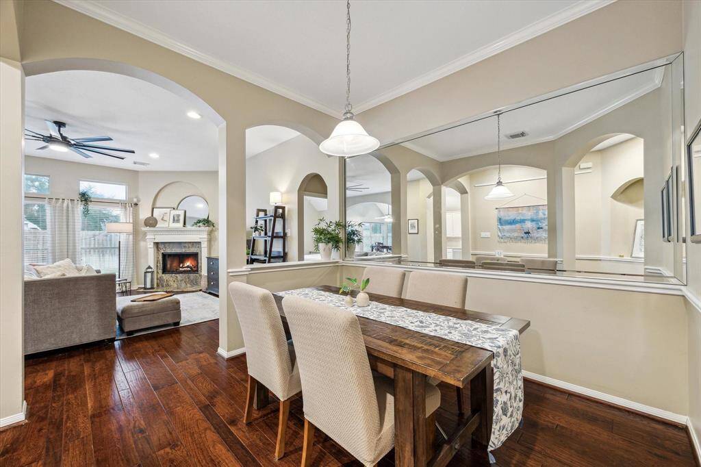 The dedicated dining area has plenty of room for your favorite dining table and chairs.  Beautiful arched entry that overlooks the living area.  The mirrored wall in this room enhances this dining space.  Note the beautiful floors.