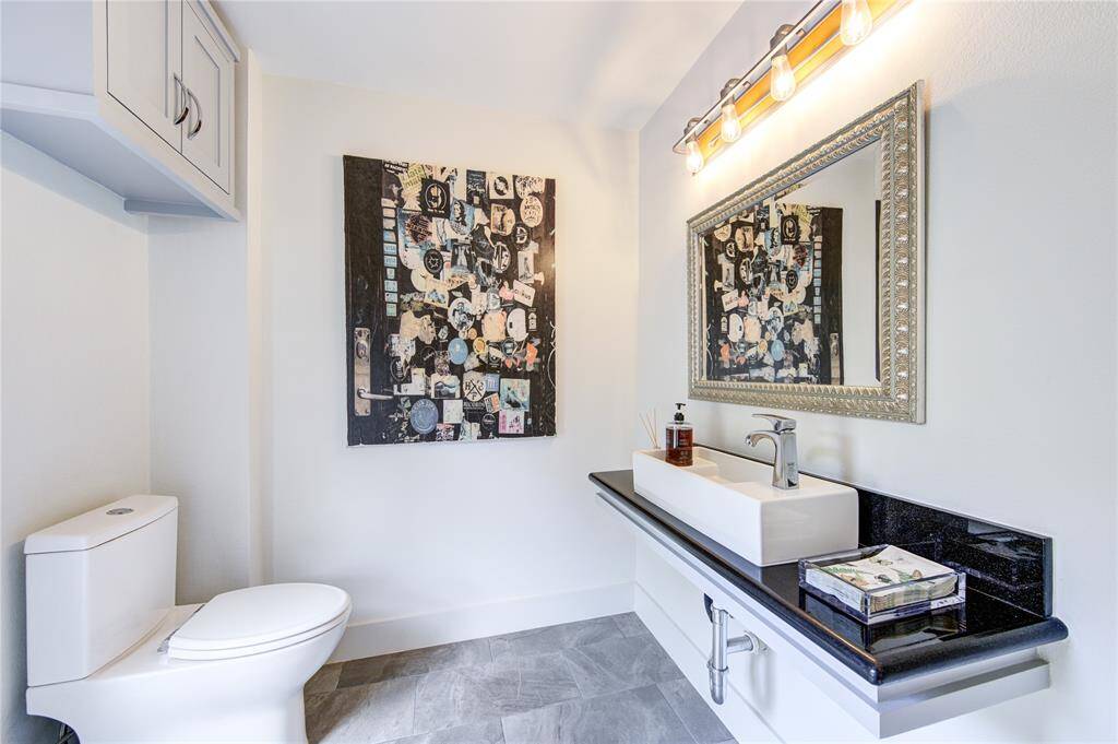The downstairs powder room is now located off the living room and has a door leading to the pool so no one has to walk through the home when in the backyard. The modern floating sink is so stylish.