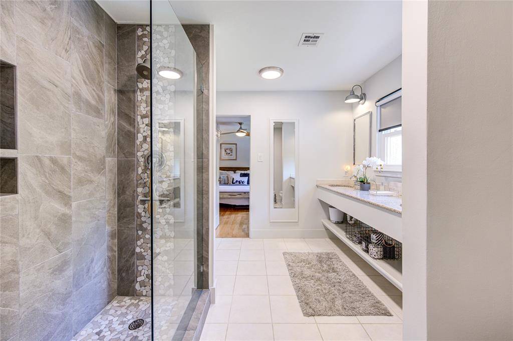 The upstairs was redesigned to create a Hollywood bathroom that two bedrooms can access directly. The walk-in shower was recently remodeled with all new tile and a frameless glass pony wall to tie in with the Modern Farmhouse design found throughout this home.