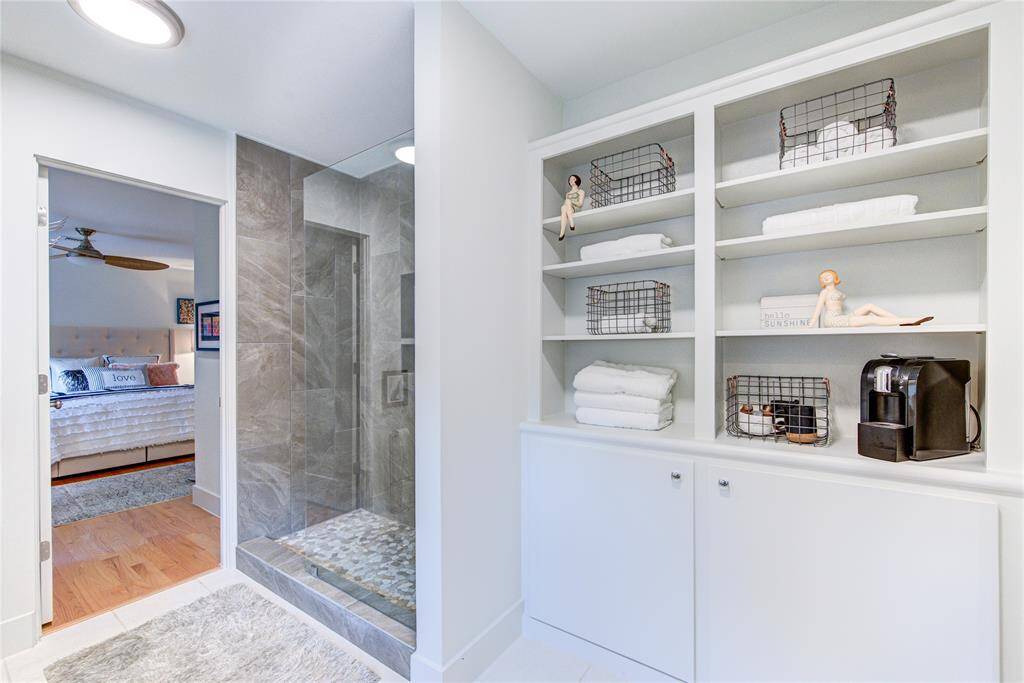 It is rare to find so much storage in a bathroom, but the former door to the bathroom has been converted into a built in cabinet with shelves for additional storage.