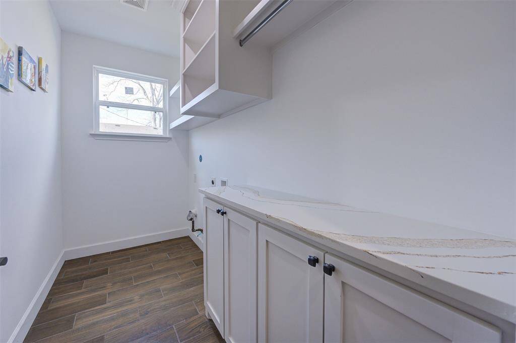Laundry area with folding table and cabinets.