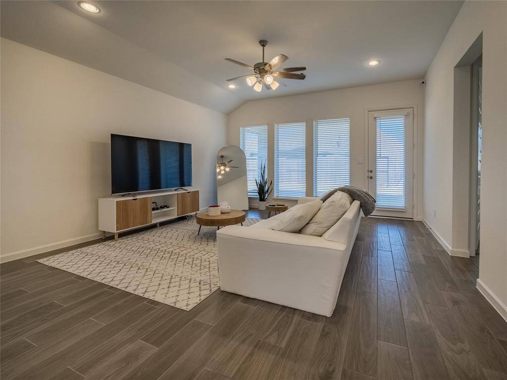 the family room also has the extra long windows that face the covered patio , the entrance on your right is the entrance to the primary bedroom