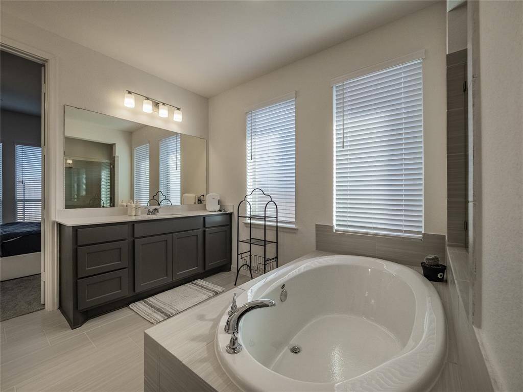 primary bath has your soaking tub, double vanities great lighting lots of natural light