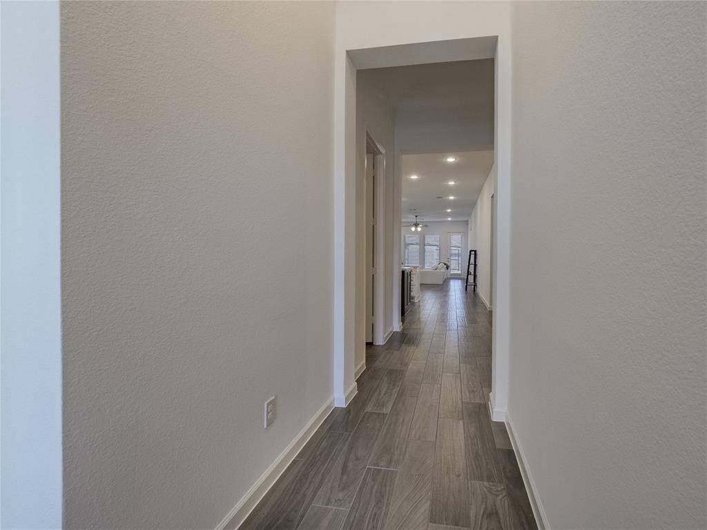 from this view of the entrance hall you also see on your right the entrance to the 2 car garage that also has poxy flooring on the left is the guest suite and the second entrance on the left is the laundry room all the way back is the wall of windows in your family area