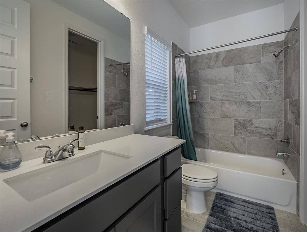 guest suite bathroom with shower/tub combo granite counter tops tile flooring