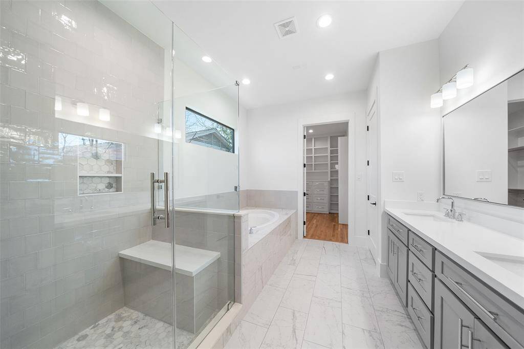 Updated Primary bathroom with marble accents and double sinks.