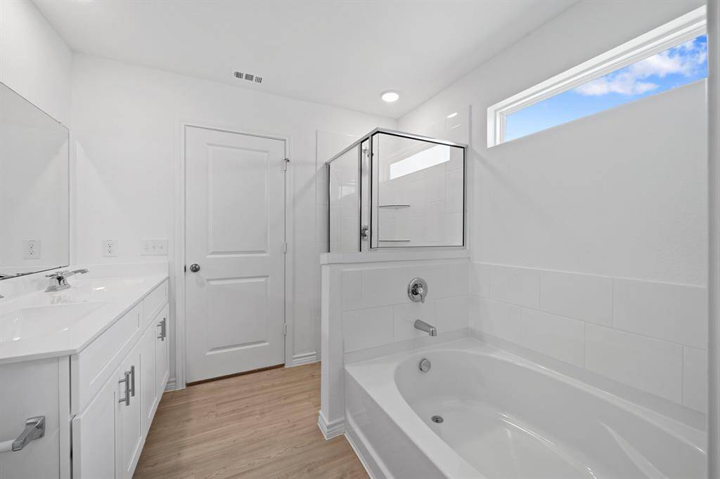 primary ensuite bathroom with garden tub and walkin shower as well as double sinks
