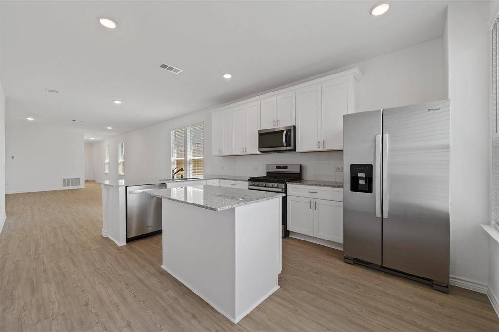 Kitchen featuring Whirpool Stainless Steel appliances, 5 burner Gas stove, and granite countertops