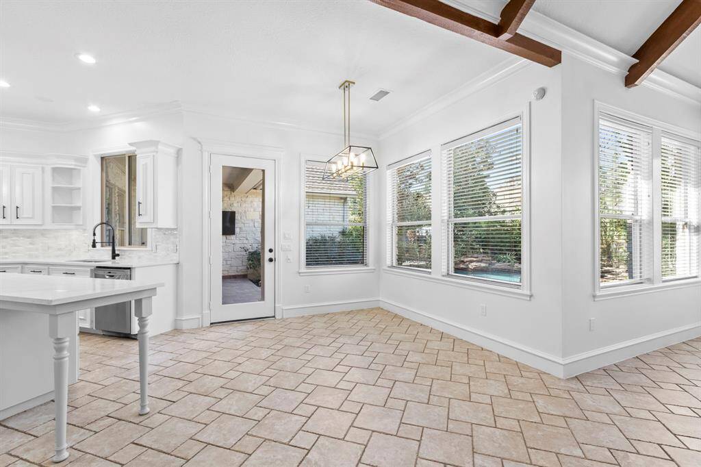 Large breakfast nook, seamlessly connected to the kitchen and family room, offering a scenic view of the backyard pool area.