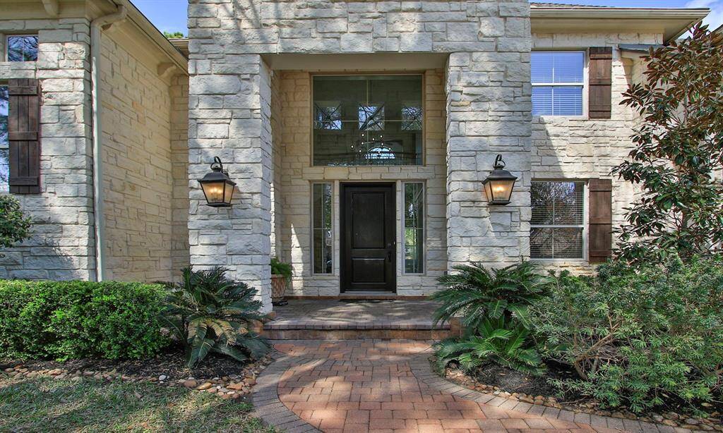 Impressive curb appeal with a Limestone facade, stone-paved driveway, and walkway.