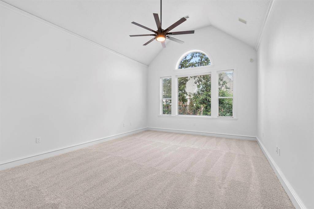 Primary bedroom downstairs is very spacious with large picture windows overlooking the private backyard oasis.