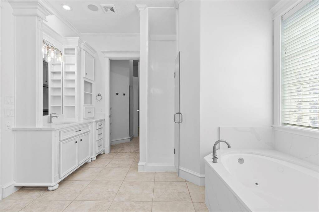 Separate shower, his & her vanities and a multitude of cabinetry & drawers.