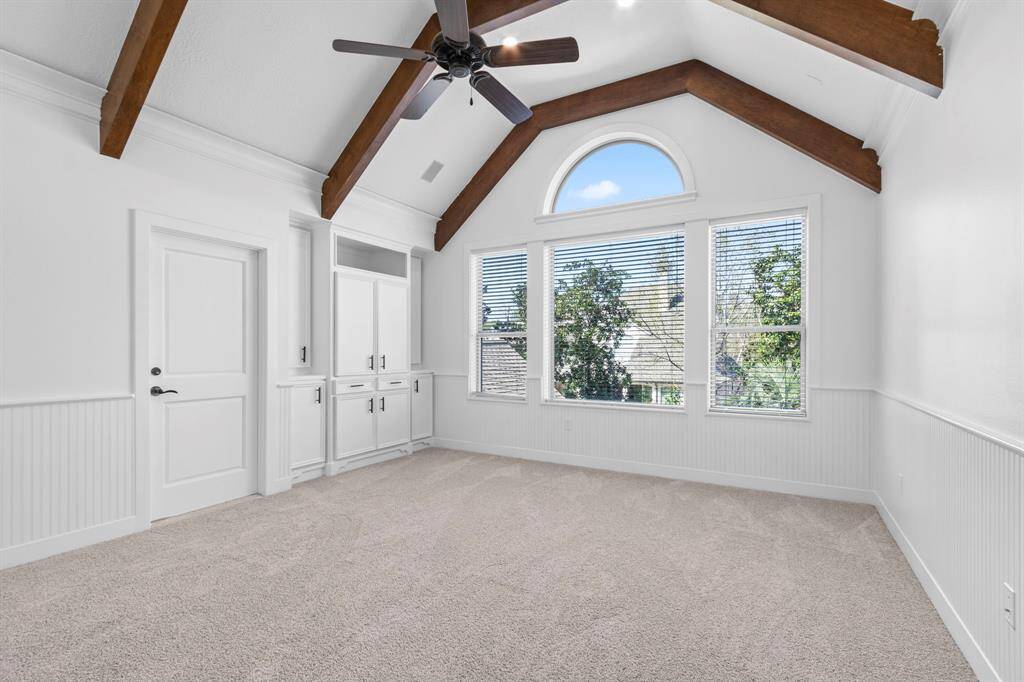 Huge game room upstairs with striking wood beams, wainscoting, and ample built-in storage.