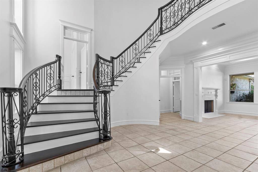 A grand wrought iron staircase with a mid-level study located at the landing.