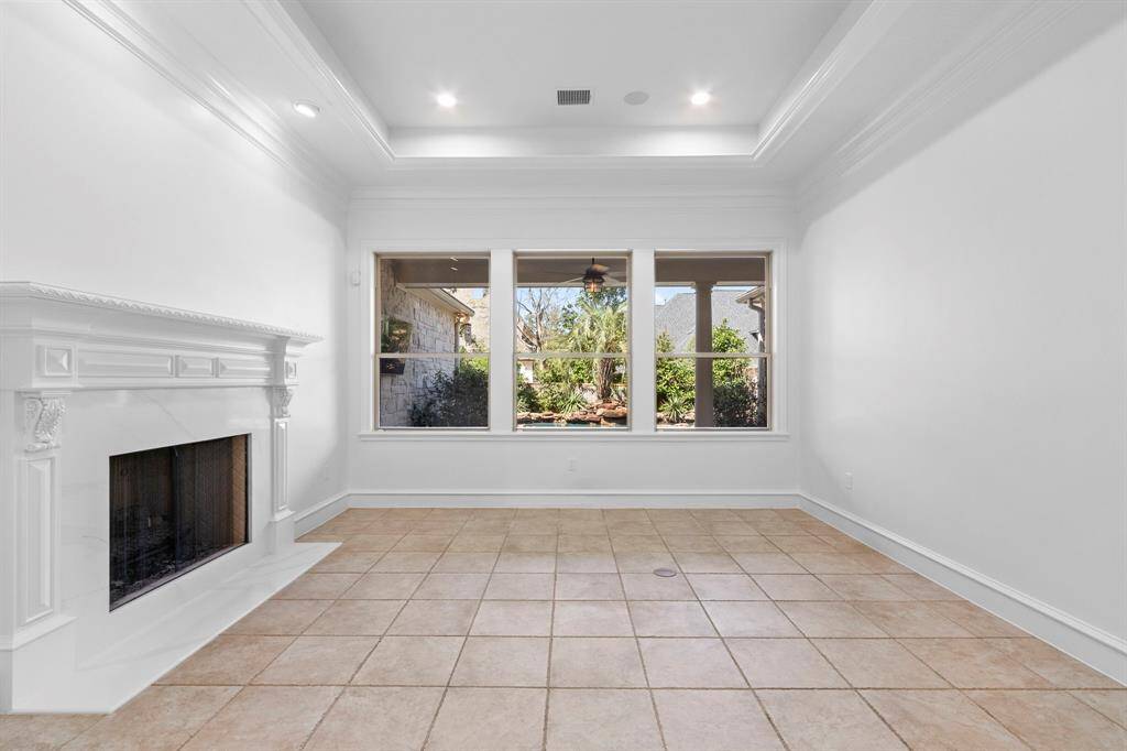 Formal living room with Quartz fireplace surround with picture windows overlooking the pool and backyard paradise.