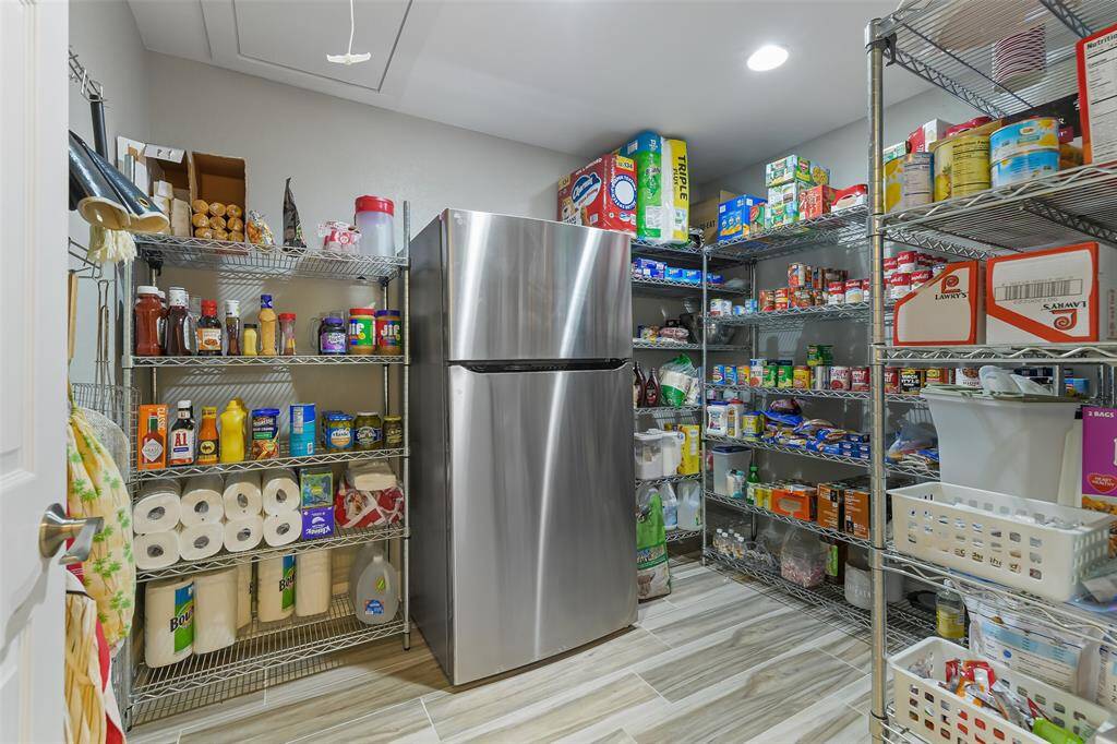 Expansive 8x10 walk-in pantry with ample storage and plumbed for a refrigerator.