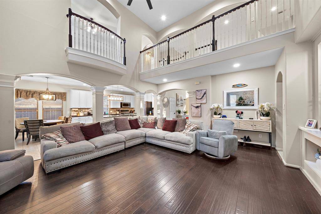 Dark hardwood floors enhance the room's sophisticated aesthetic, while the arched entryways and custom millwork add timeless architectural detail.
