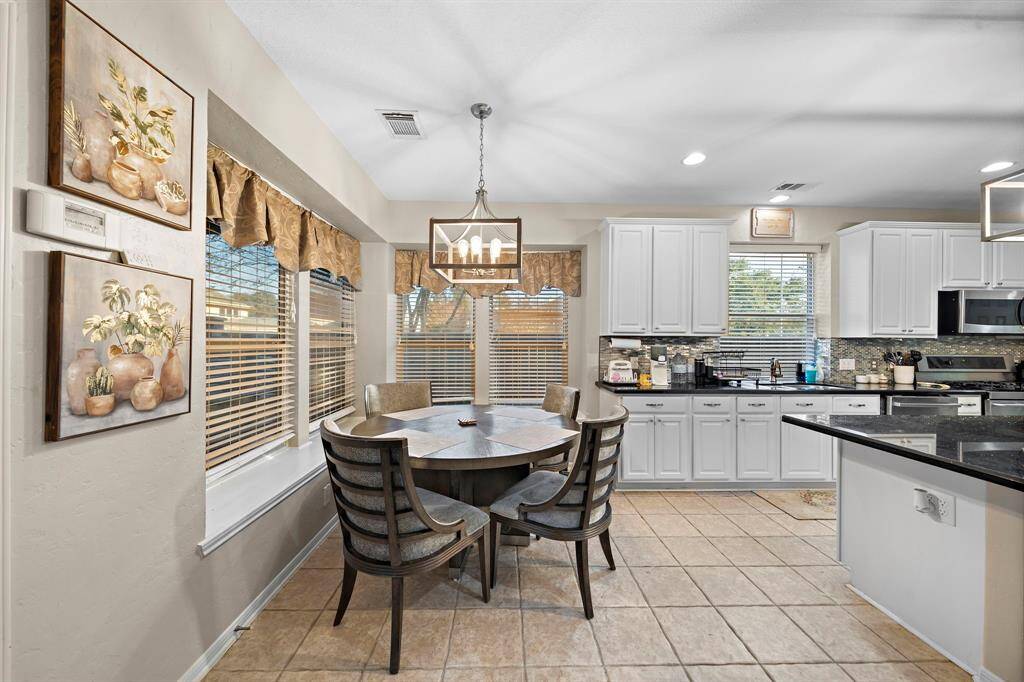 The breakfast room, surrounded by windows, offers a cozy yet bright space to start your day. Its proximity to the kitchen creates the perfect spot for informal meals while maintaining the home’s open flow.