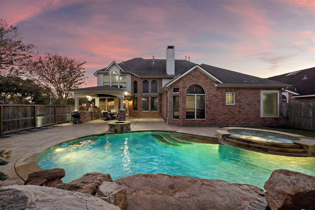 Welcome to your private backyard oasis, where luxury meets tranquility. This stunning space features a sparkling resort-style pool and spa, a built-in outdoor kitchen under a covered patio, and elegant stone accents surrounded by lush landscaping. With strategically placed landscape lighting and ample space for lounging or entertaining, this retreat is perfectly designed for both relaxation and memorable gatherings.