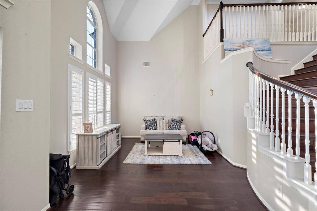This bright and airy sitting area features soaring ceilings and a staircase view, creating an open and connected atmosphere. The arched walkways add a touch of timeless elegance.